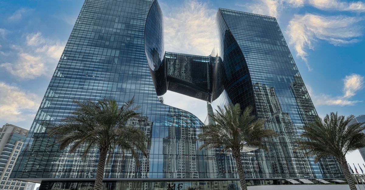 A modern glass building in Business Bay, Dubai, framed by palm trees