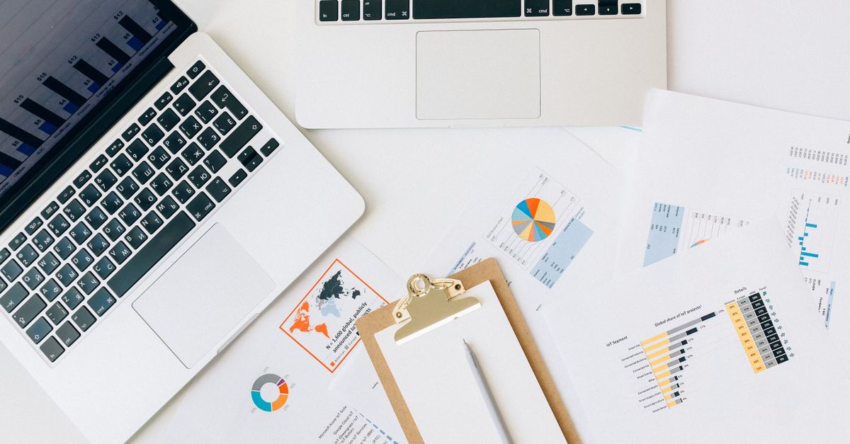 A laptop, printed charts and reports laid out for a cash-flow analysis