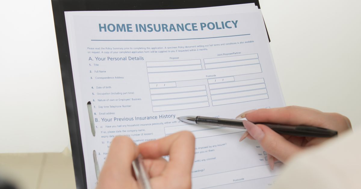 Hands completing a printed policy document with a pen
