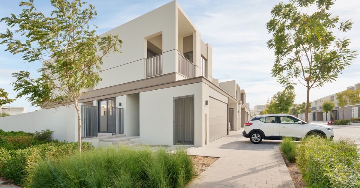 A contemporary villa in Dubai with a car parked outside and mature landscaping