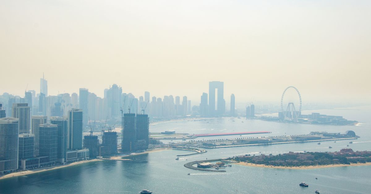Aerial view of Dubai Marina at golden hour with residential towers lining the waterway