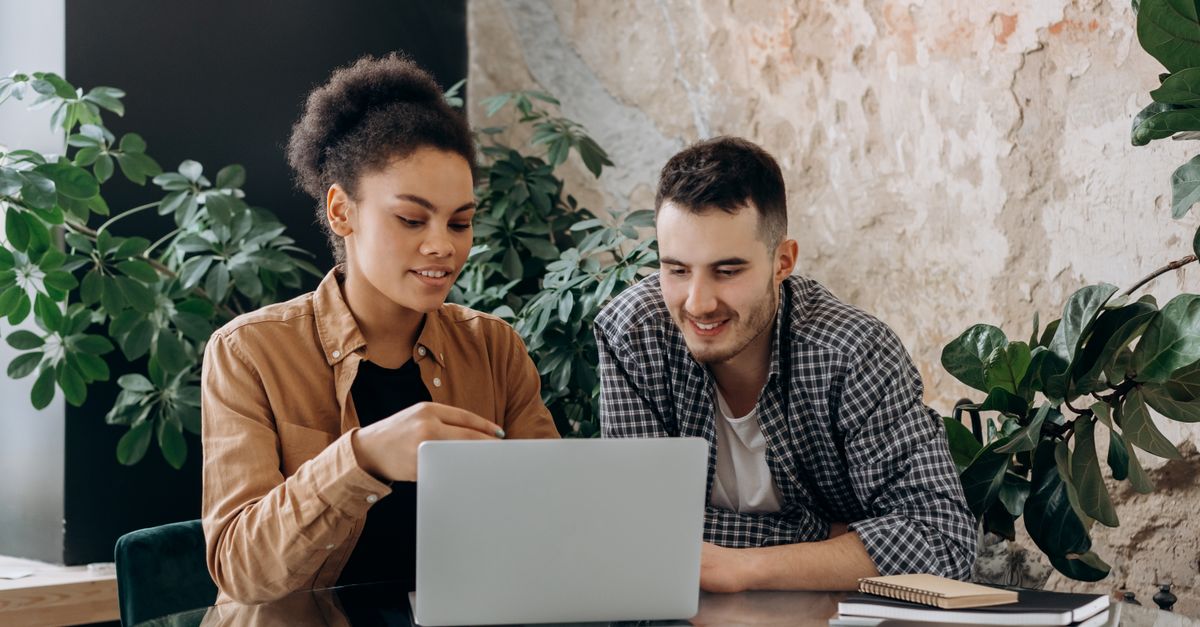 A couple sitting together at a laptop working out their home finances
