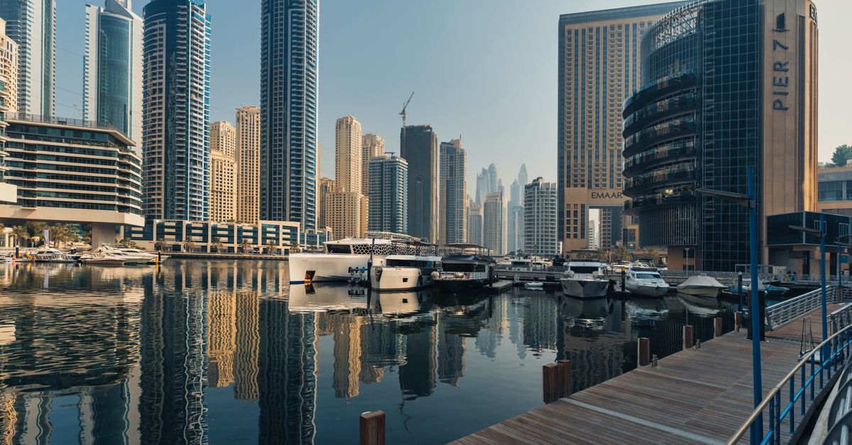 The Dubai Business Bay waterfront lined with modern towers under a bright sky