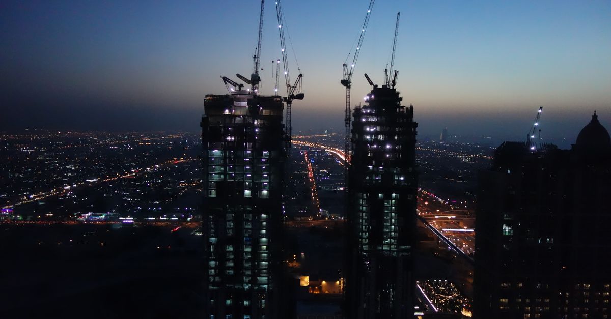 Off-Plan vs Ready Property in Dubai: A 2026 Data Comparison 1 Dubai's skyline at dusk with illuminated construction cranes