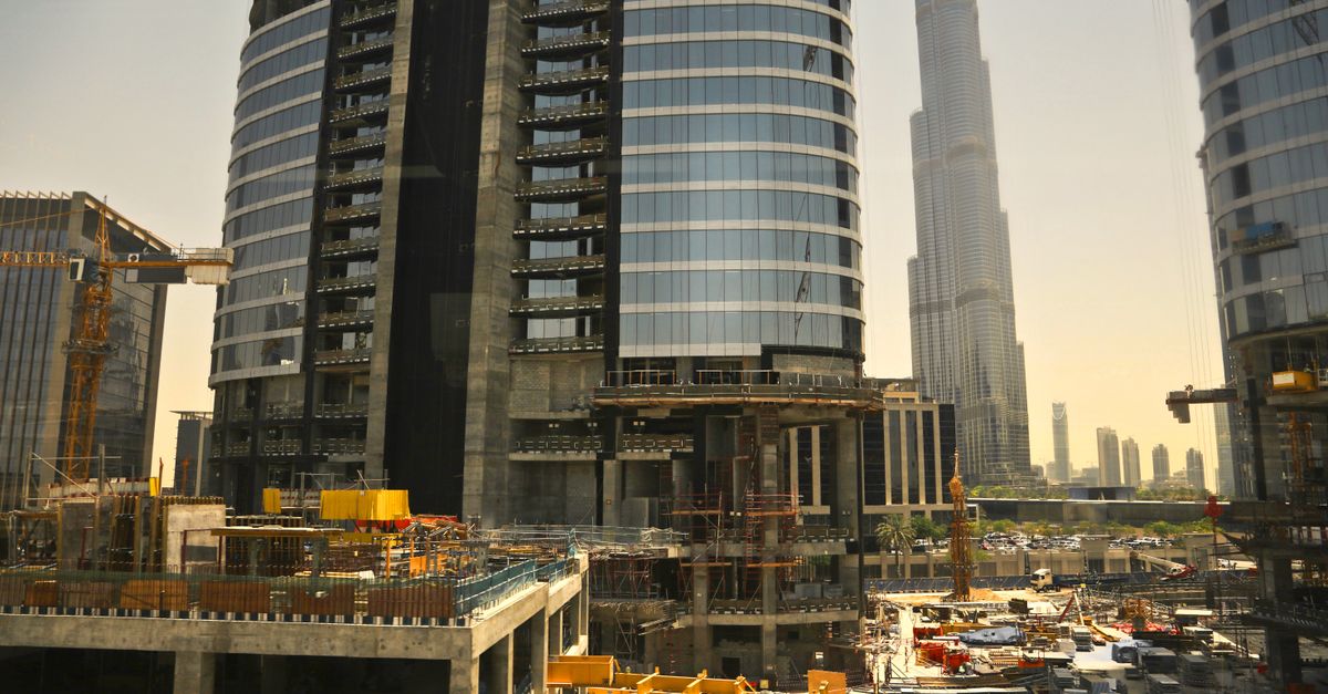 An active construction site in Dubai with the Burj Khalifa behind it