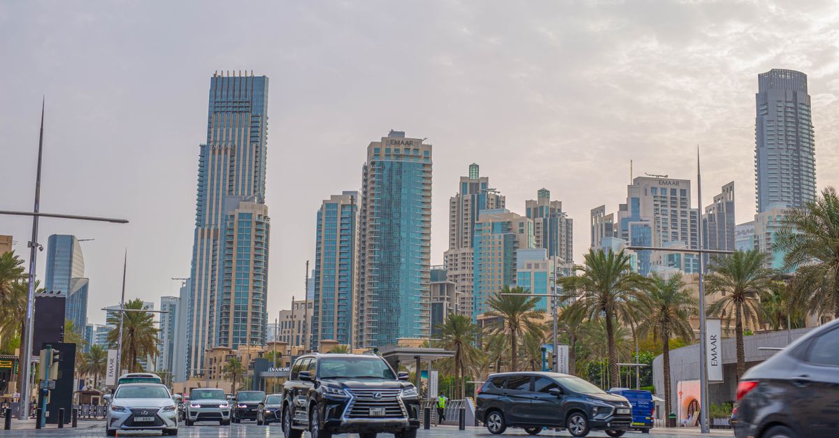 A busy Dubai road with towers rising behind the traffic
