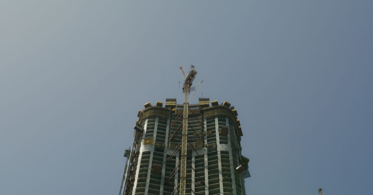 How to Resell Off-Plan Property Before Handover in Dubai 1 A high-rise building under construction in Dubai with a tower crane against a blue sky
