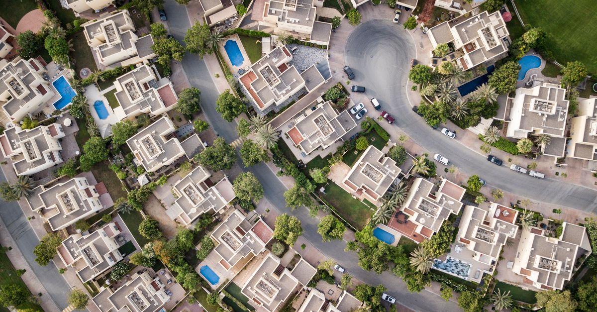 Top-down aerial view of a Dubai villa community with private pools and landscaped plots