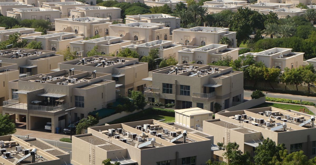 Aerial view of a low-rise villa community in Dubai, showing rows of detached villas surrounded by mature landscaping