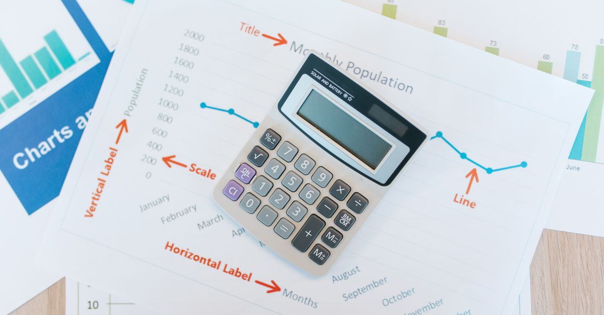A calculator resting on printed financial charts and reports
