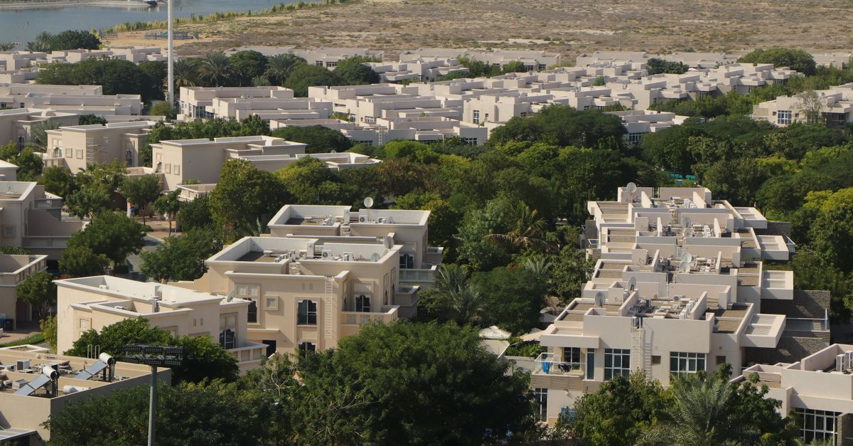 Aerial view of a Dubai residential community of detached family villas set among trees and gardens