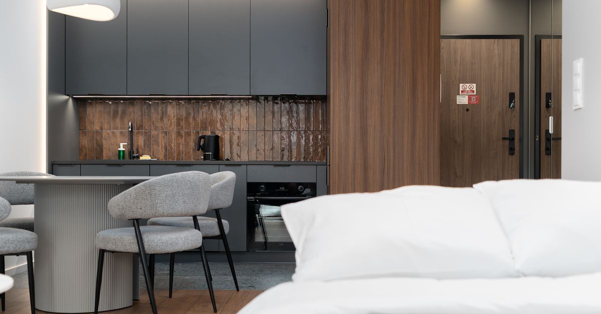 A stylish modern apartment interior with a compact kitchen and dining area