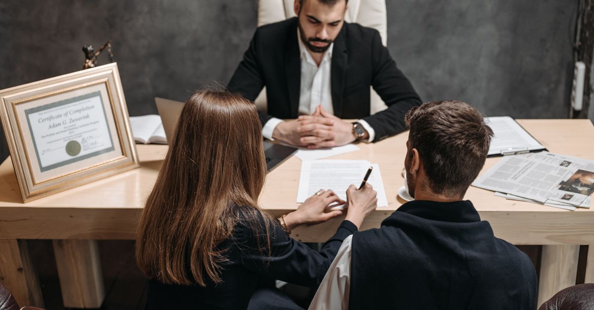 A lawyer discussing legal documents with clients in an office