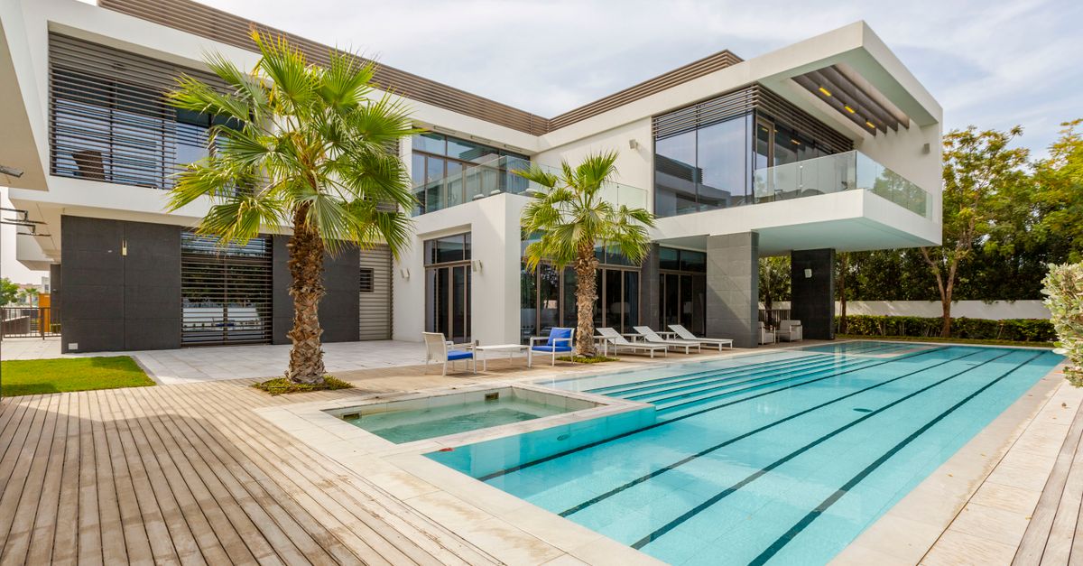 A luxury modern villa in Dubai with a swimming pool and palm trees