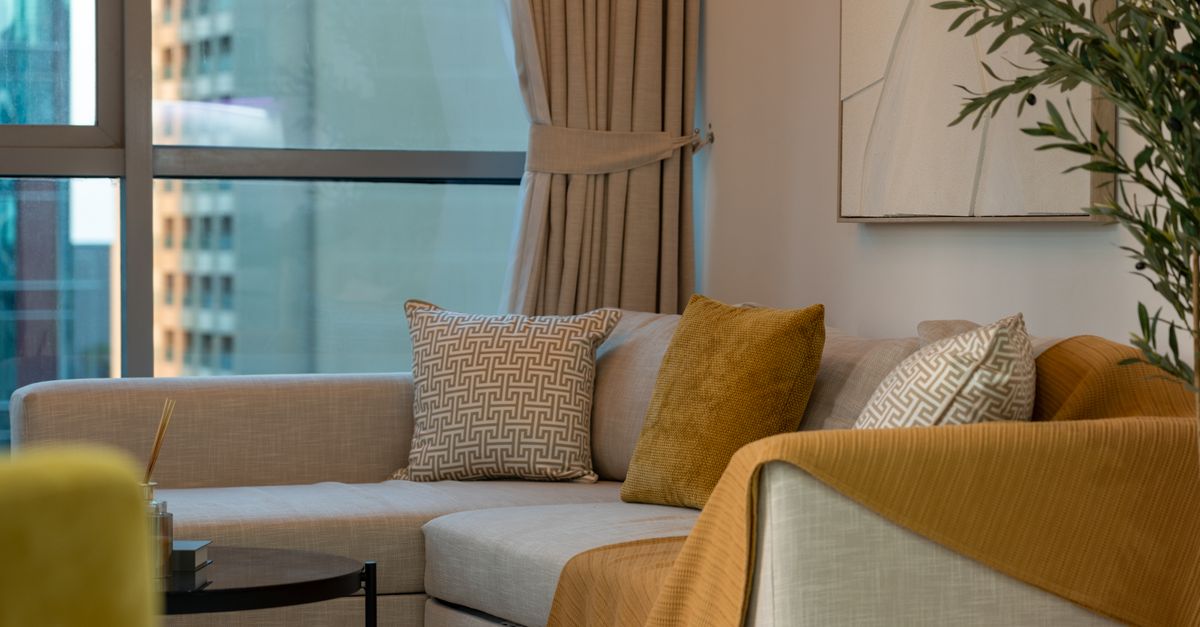 A bright modern apartment living room with a sofa and a city view