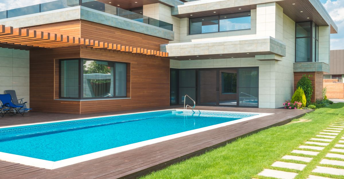 A modern house with a swimming pool and a green garden