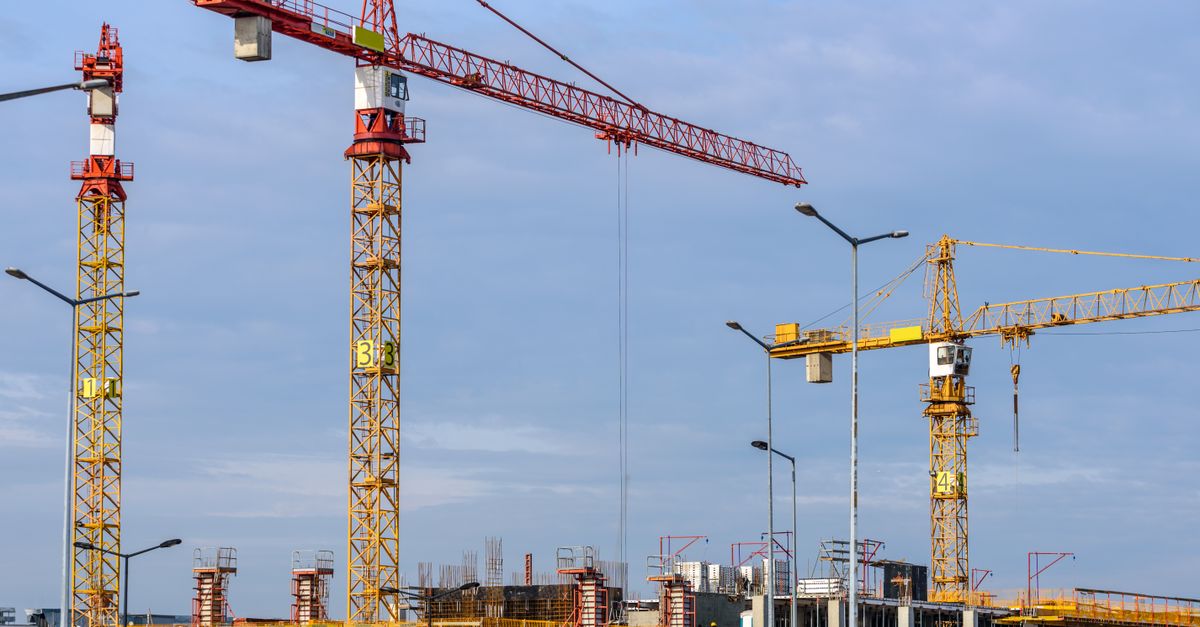 Multiple tower cranes working across a large construction site