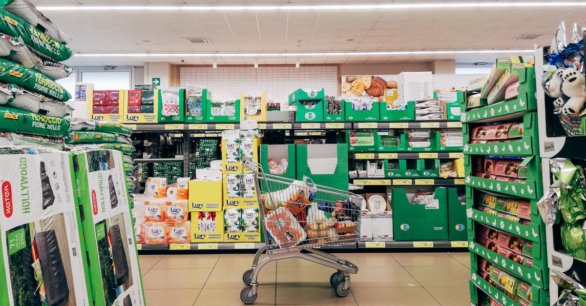A shopping trolley in a bright supermarket aisle