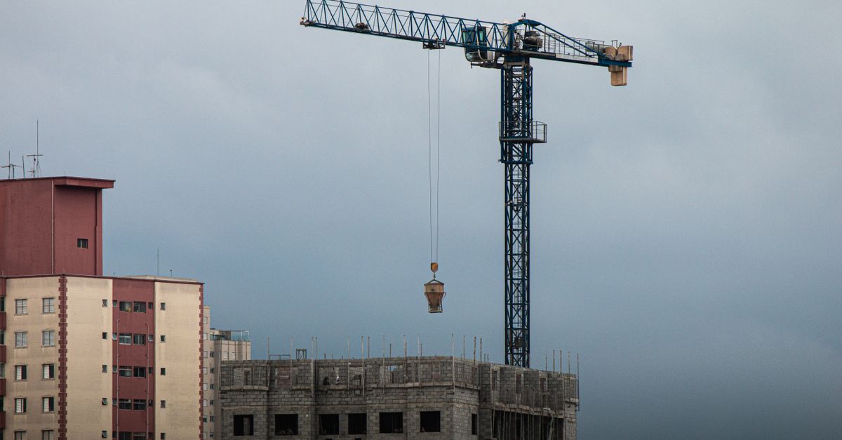 A tower crane lifting materials over a high-rise construction site
